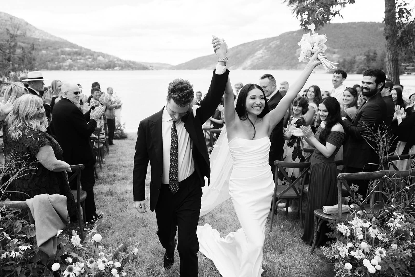 Newlyweds celebrating as they come down the wedding aisle